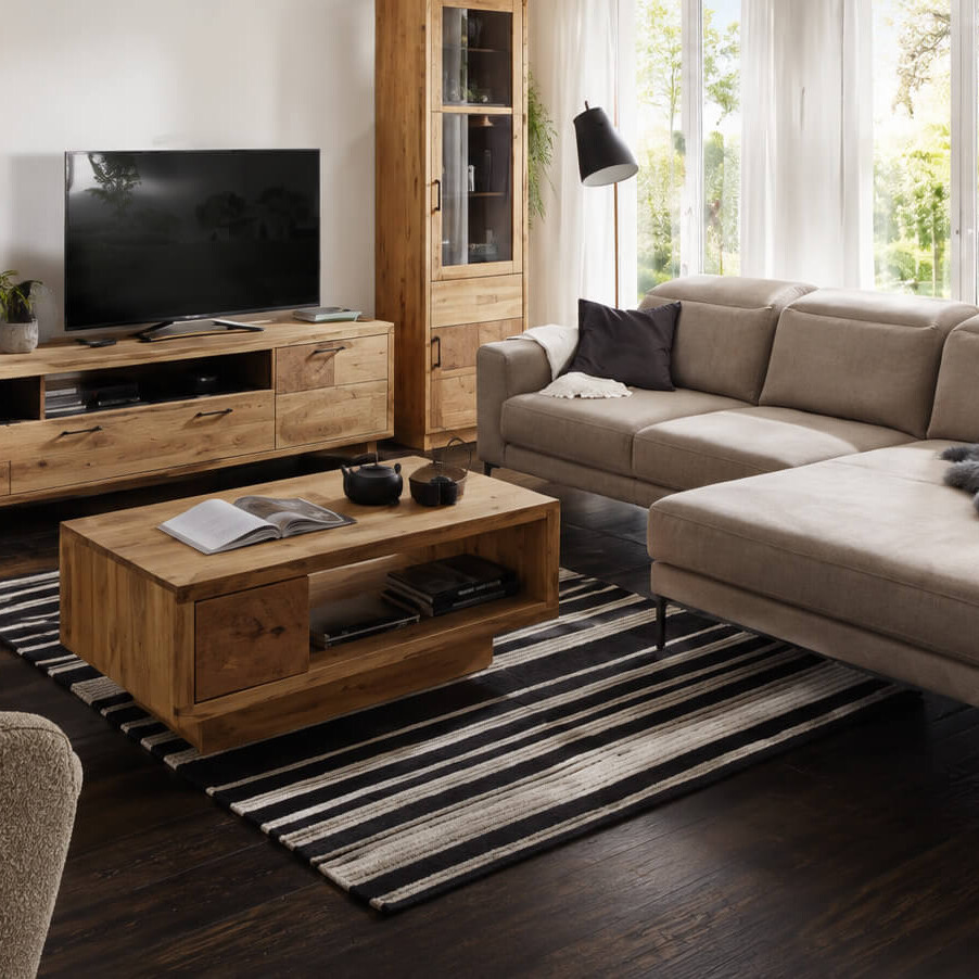 Wohnzimmer mit Holzmöbeln, Textilien und natürlichen Materialien