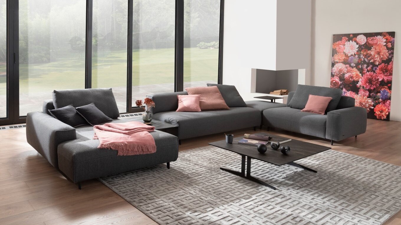 Moderne Wohnlandschaft mit Longchair vor einer großen Fensterfront