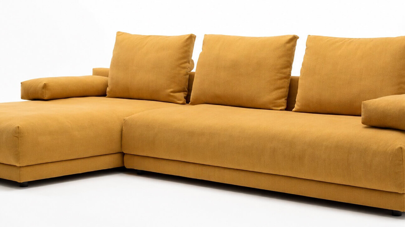 Gelbes Sofa von freistil Rolf Benz vor hellem Hintergrund