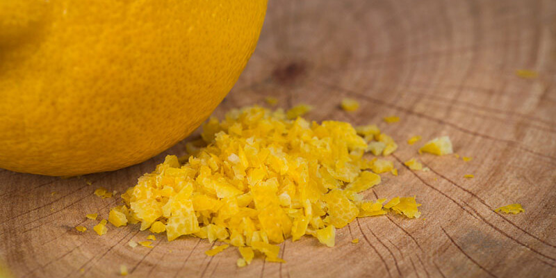 Geriebene Zitronenschale auf Holzbrett