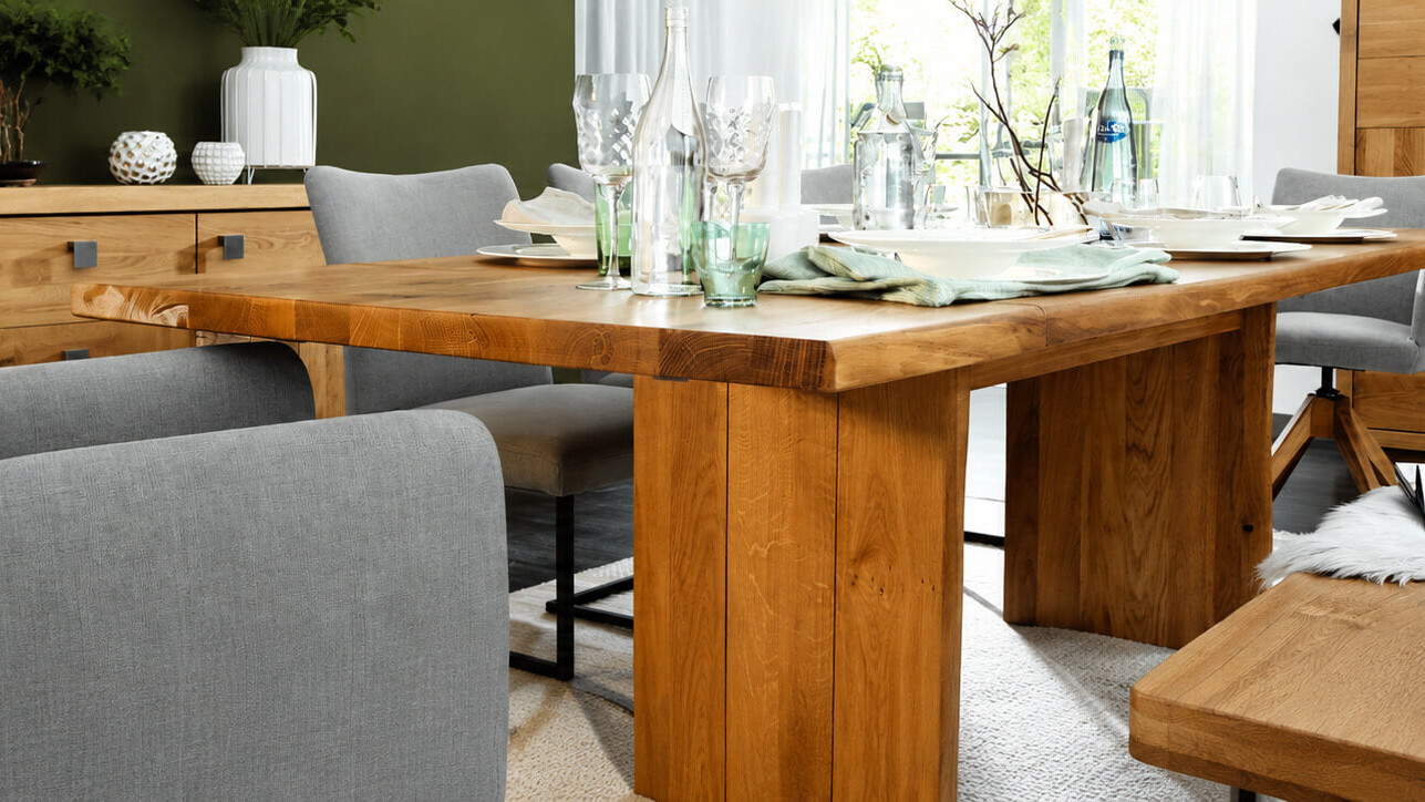 Massiver Holzesstisch von Natura Home in einem hellen Wohn- und Essbereich