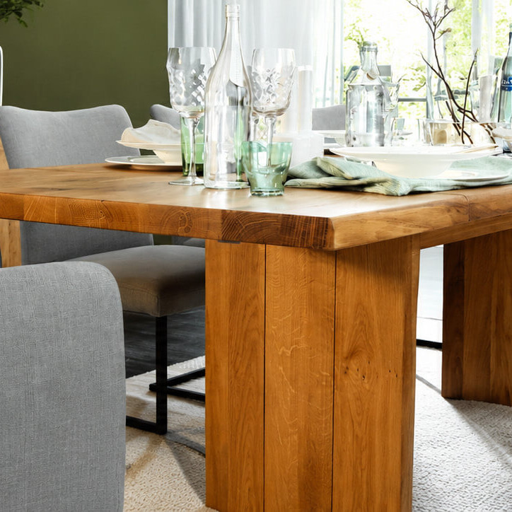 Massiver Holzesstisch von Natura Home in einem hellen Wohn- und Essbereich